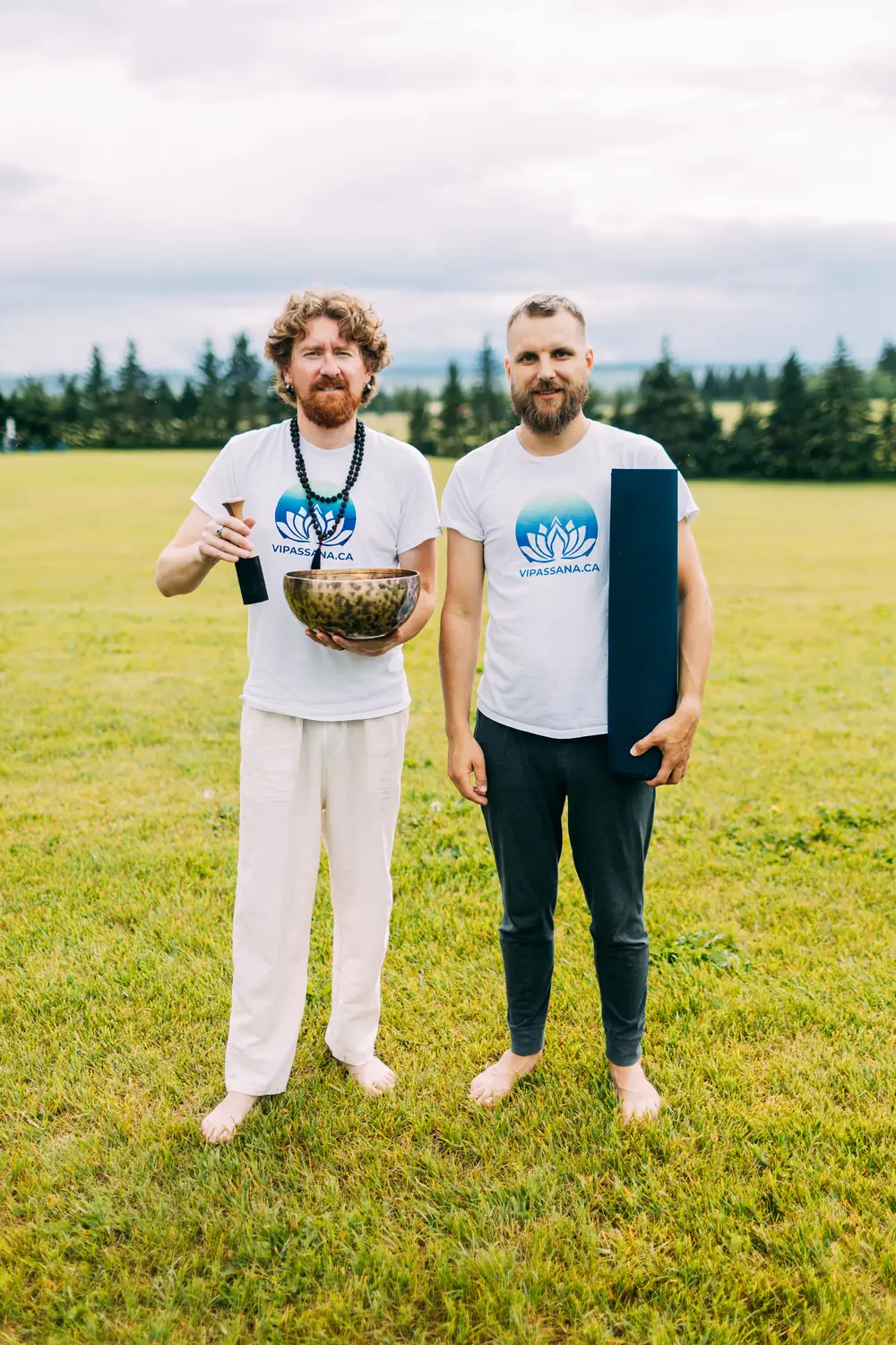 Artem Rusinov with a Tibetan singing bowl and Valerii Bandurko with a yoga mat, the teachers of Vipassana.ca, outdoors in Alberta
